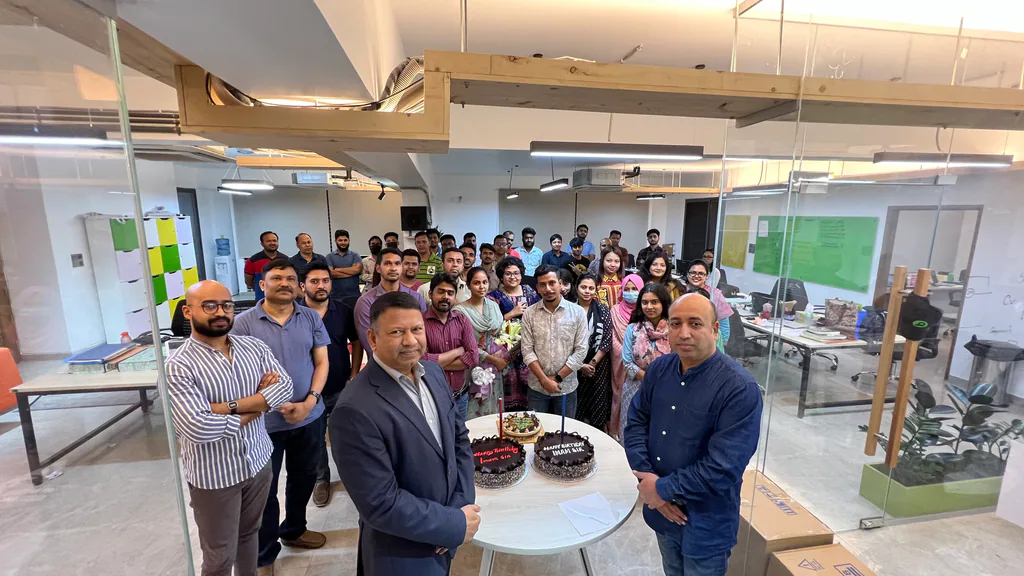 The Gononet team gathered around a celebration cake in the open-plan office.