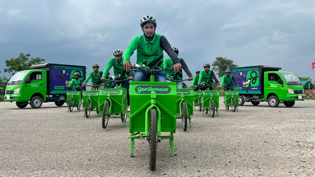 GorillaMove riders in green uniform on a fleet of branded electric cargo trikes and delivery vans.