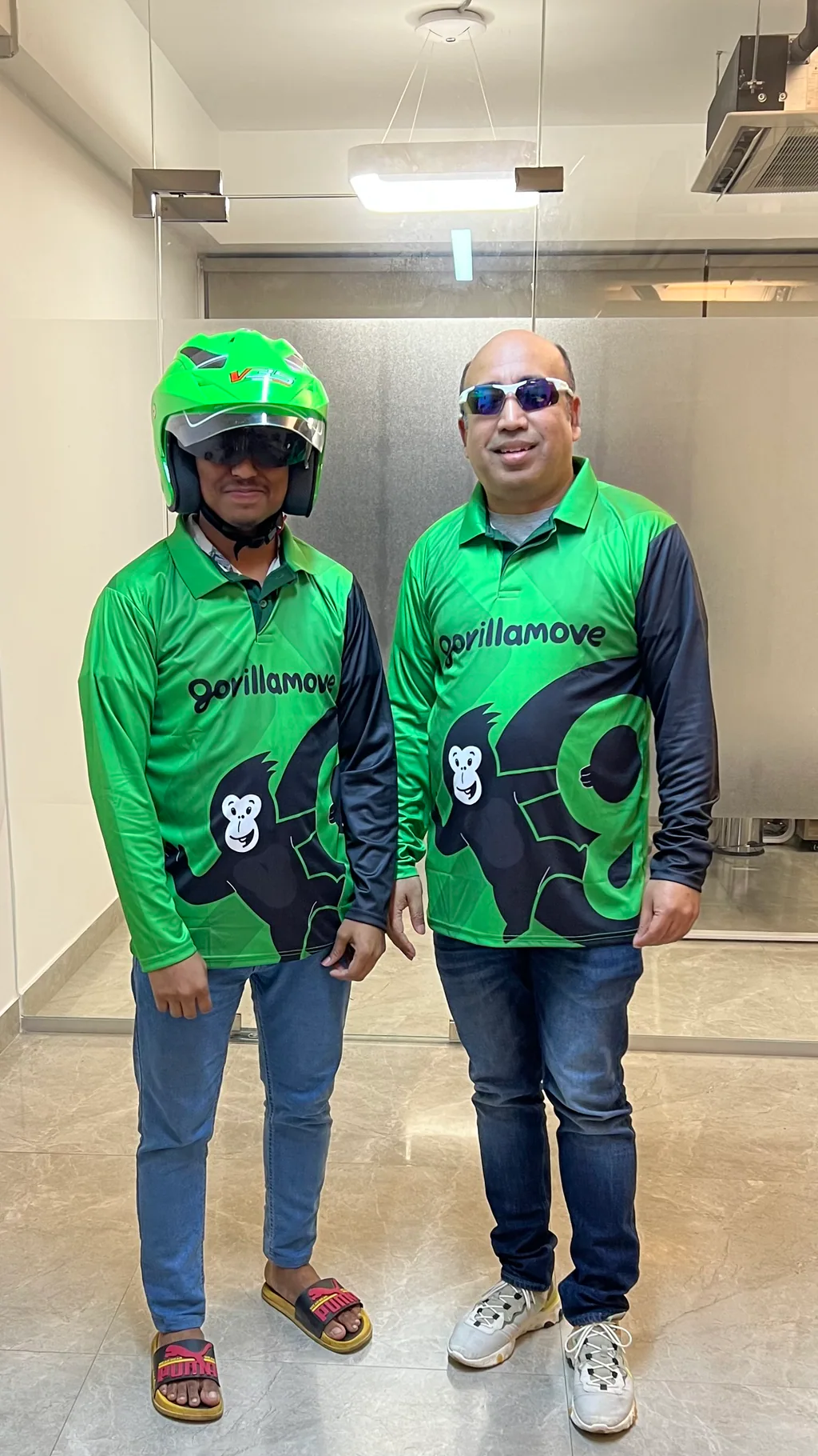 Shawkat Islam and a colleague in GorillaMove branded green jerseys, one wearing a rider helmet.